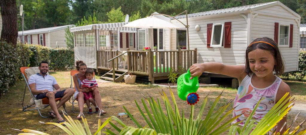 Famille devant Mobil home au camping Les Pierres Couchées